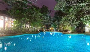 a swimming pool in a resort at night at Sawasdee Village in Kata Beach