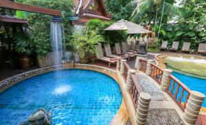 a swimming pool with a waterfall in a resort at Sawasdee Village in Kata Beach