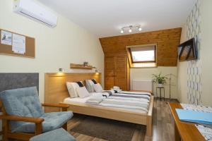 una camera da letto con un letto, una sedia e una scrivania di Ács Apartman a Hévíz