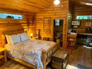 a bedroom with a bed in a log cabin at Gables Cedar Creek Inn in Twain Harte