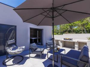 a patio with chairs and an umbrella and a table at Villa David by Interhome in Medulin +37 photos