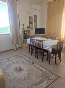 a dining room with a table and chairs and a television at Mono Lu Lioni in Lu Lioni