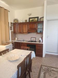 a kitchen with a table with chairs and a counter top at Mono Lu Lioni in Lu Lioni +5 photos