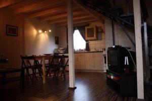 a kitchen and dining room with a table and a tv at Domek KLIMATYZOWANY piętrowy - Domki u Staszka in Rusinowo +4 photos