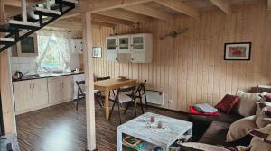 a kitchen and a living room with a couch and a table at Domek piętrowy klimatyzowany, ogrzewany z jacuzzi na terenie ośrodka- Domki u Staszka in Rusinowo