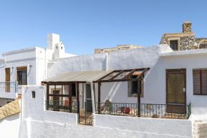 - un bâtiment blanc avec une terrasse couverte et un balcon dans l'établissement 1900s traditional house in Asklipio, à Asklipiḯon 10 autres photos