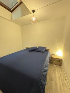 een slaapkamer met een bed met twee kussens erop bij Le Nocturno in Cluses