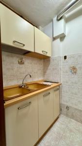 塞斯特雷Hostdomus- Terrace Apartment的带白色橱柜和水槽的厨房