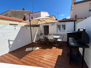 a patio with a table and an umbrella on a deck at Belle petite maison proche de la mer in Les Sables-dʼOlonne