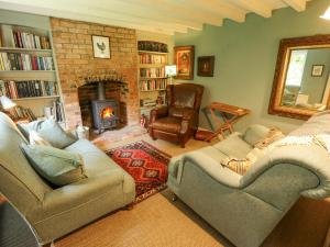 ein Wohnzimmer mit zwei Sofas und einem Kamin in der Unterkunft Sunny Cottage in Grantham