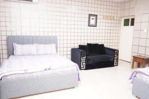 a bedroom with a bed and a chair in it at ghroob farmhouse villa in Al Ḩamrānīyah