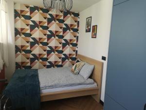 a bedroom with a bed with a geometric wall at Apartament Lwowska in Lublin