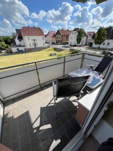 a balcony with a table and a chair on a roof at Ferienwohnung - Monteurwohnung Büren in Büren