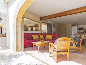 a living room with a red couch and chairs at Holiday Home Cucuron by Interhome in Cucuron