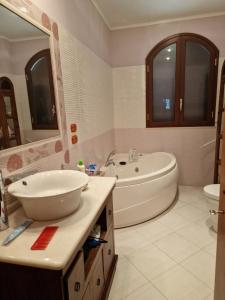 y baño con bañera, lavabo, bañera y aseo. en Villa Mary Sol, en Savoca