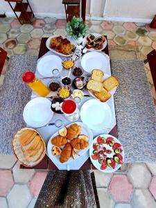a table with many plates of food on it at Vila Eni - Mario in Ksamil +37 photos