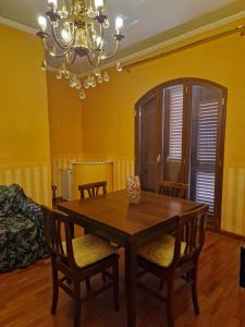 Un comedor con mesa y sillas de madera. en Villa Mary Sol, en Savoca 8 fotos más