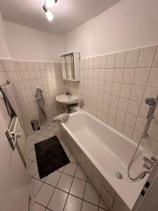 a white bathroom with a tub and a sink at Apartment Diez in Diez
