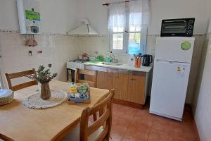 een keuken met een tafel en een witte koelkast bij Casa Cedrón in La Cumbre