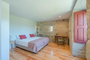a bedroom with a bed and a red door at Feel Discovery Casa da Granja Douro Valley in Resende