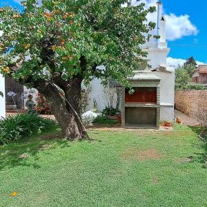 een boom in een tuin naast een huis bij Casa Cedrón in La Cumbre
