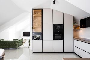 a living room with white cabinets and a green couch at Sea view APARTMENT PEPE in Podstrana