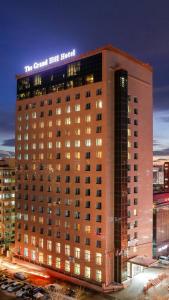 a large building with a sign on top of it at Grand Hill Hotel Ulaanbaatar in Ulaanbaatar