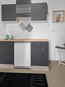 una cocina con encimeras y armarios en blanco y negro en Stockerau Comfort Studio 1BR for 2, en Stockerau 7 fotos más