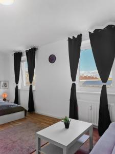 sala de estar con cortinas negras y mesa en Stockerau Comfort Studio 1BR for 2, en Stockerau