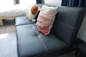a stuffed dog sitting on a couch with a pillow at Private Hotel Asakusa in Tokyo