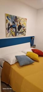 un letto con cuscini colorati sopra di Blumon guest House a Napoli