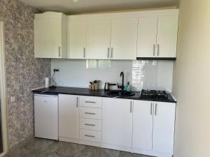 a white kitchen with white cabinets and a sink at ARM Garden EVN Zvartnots in Pʼarakʼar
