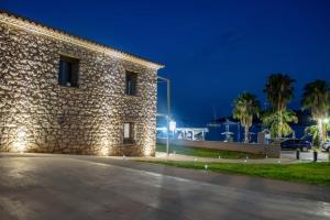 a building with a stone wall at night at Vivari Stone House in Vivari