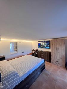 a bedroom with a bed and a flat screen tv at Santa Giulia Seascape & Garden Rooms in Crocetta