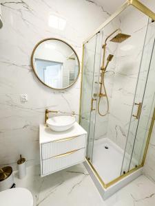 a bathroom with a sink and a mirror at Złote Apartamenty Kłodzko in Kłodzko