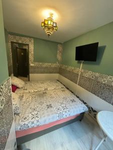 a bedroom with a bed and a tv on the wall at Chambre d hôtes Arcis sur Aube in Arcis-sur-Aube