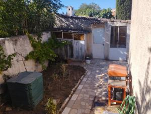 马赛Maison individuelle avec jardin的有垃圾桶和木椅的房子 更多1张照片