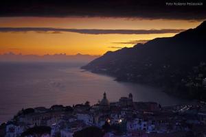 a view of a city at sunset with the ocean at Casa Vacanze Bouganvillea in Cetara