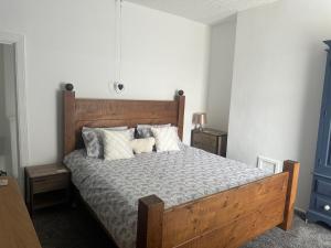 Un dormitorio con una gran cama de madera con almohadas. en Family house, en Oldham
