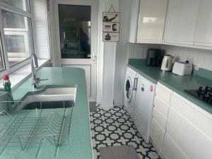 una cocina con fregadero y lavadora en Family house, en Oldham