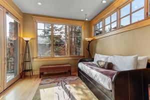 a living room with a leather couch and windows at Kokomo Lodge in Copper Mountain +19 photos