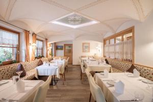 a dining room with white tables and chairs at Hotel Lago della Creta in San Vigilio Di Marebbe