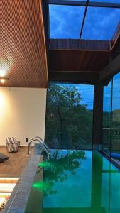 een zwembad in een huis met een groot raam bij Casa 422 - Loft Bromélia in Santana do Riacho +29 foto's