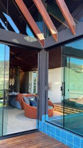 a house with glass doors and a living room at Casa 422 - Loft Bromélia in Santana do Riacho +29 photos