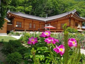 a house with pink flowers in front of it at Danyang Gahyeonjeong Pension in Danyang