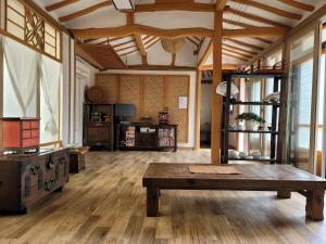 a living room with a wooden floor and a table at Paju Hanokaeseo Harureul in Paju