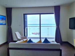 ein Wohnzimmer mit Couch und großem Fenster in der Unterkunft Suite Bay View - Charming Homestay Sapphire Halong in Hạ Long