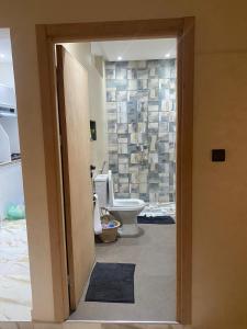 een badkamer met een toilet en een stenen muur bij Mogador Authentique T6 in Essaouira