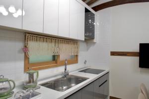 a kitchen with white cabinets and a sink at Naju DorandoranHouse Hanok in Naju
