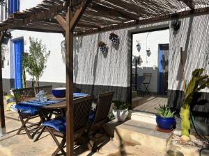 a patio with a table and chairs under a pergola at Casa Meraki - Entire Private Suite , 1 bed , Lounge Kitchen , Shower Room & More in Bédar +4 photos
